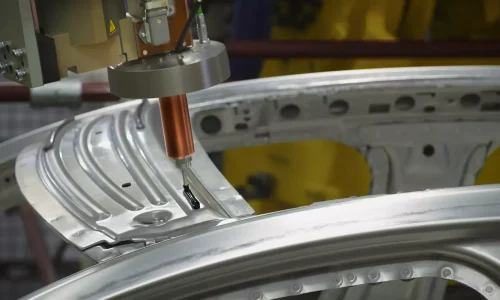 Automated dispensing nozzle applying precise adhesive or sealant onto a metallic automotive body panel in a manufacturing line, highlighting Btektech's advanced solutions for the automotive industry